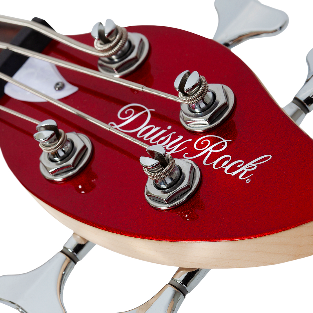 Close-up of a red electric bass guitar leaf-shaped headstock with 'Daisy Rock' branding on a white background