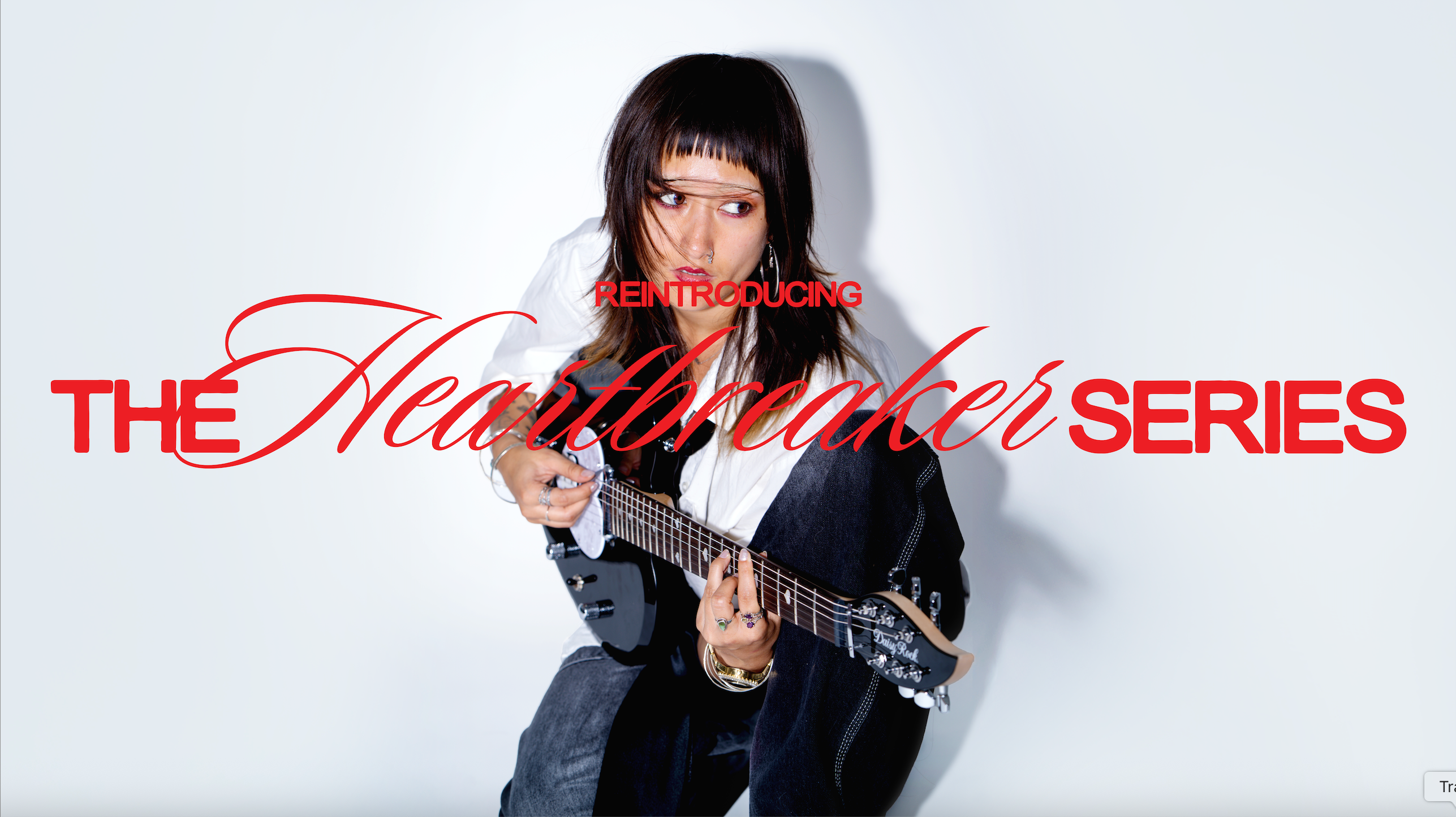 High-contrast image of a crouched model playing a black heart-shaped guitar with the words "Reintroducing The Heartbreaker Series" 