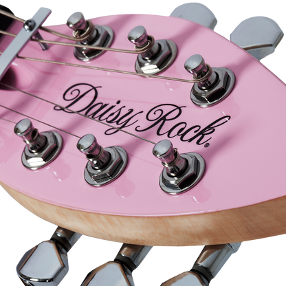 Close-up of a short scale pink electric guitar leaf-shaped headstock with 'Daisy Rock' branding on a white background
