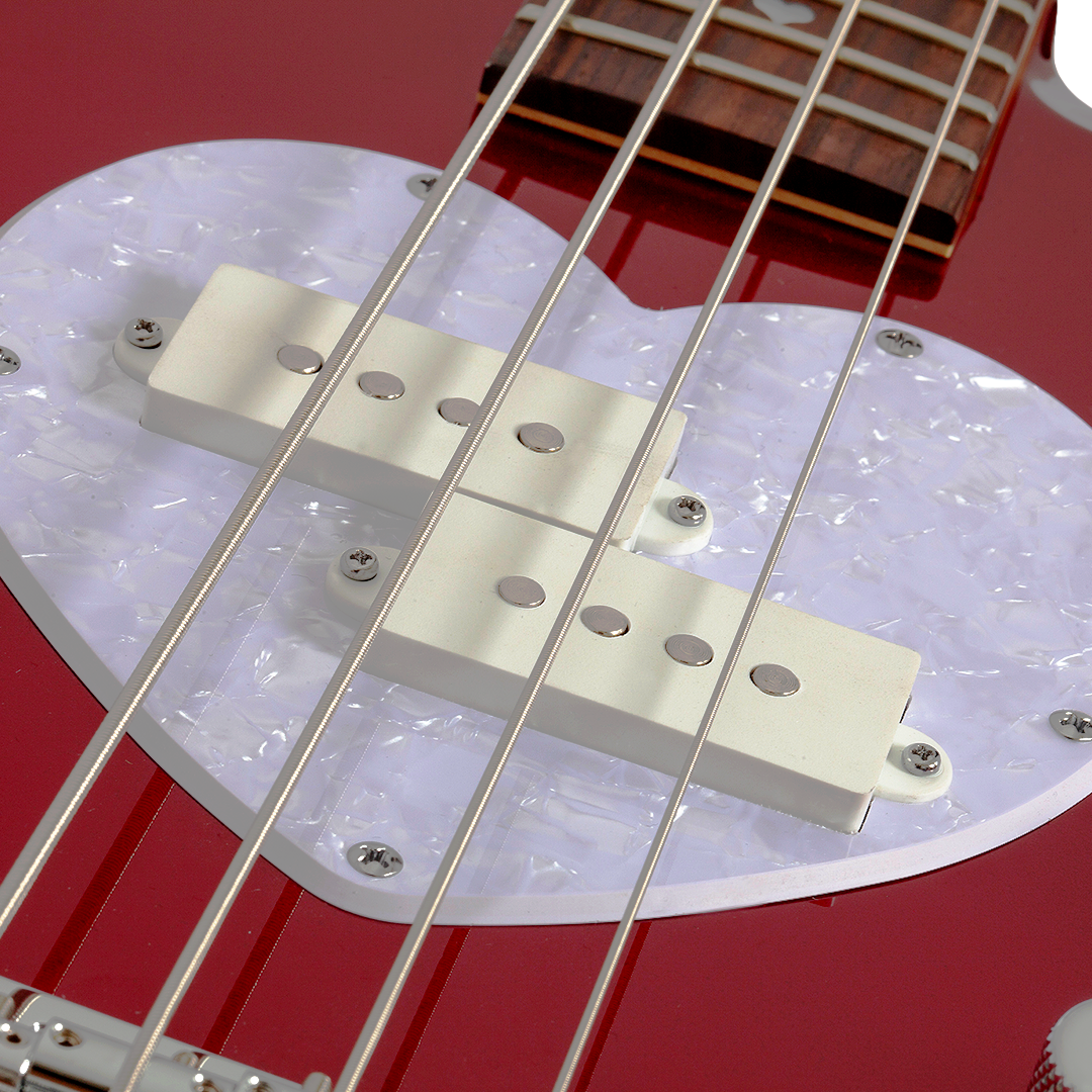 Close-up of a red electric bass guitar bridge and strings with a white pearlescent pick guard